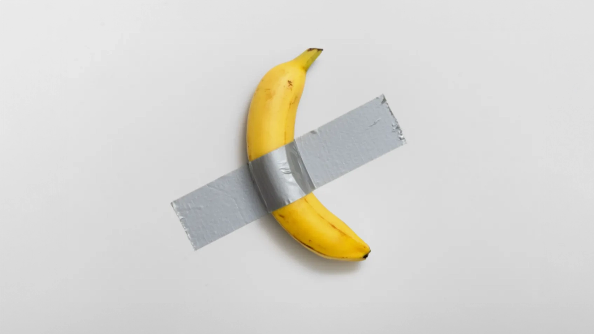 Maurizio Cattelan’s $6.2 million duct-taped banana divides the art world over meaning and madness.